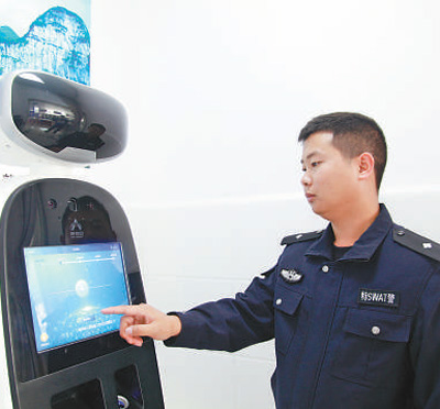 织金县珠藏镇警务助理肖发阳在展示智能机器人如何使用