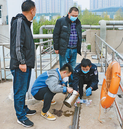 济南的禁毒民警、禁毒社工在现场采集污水样品。